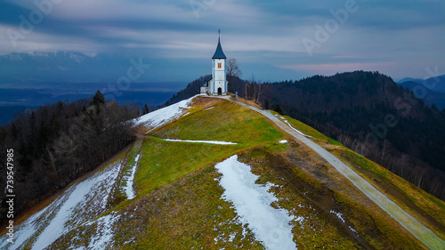 Catholic Church of St. Prim and Felician in the village of Jamnik, Slovenia. The time of the photo is in the morning in March. Remains of snow.