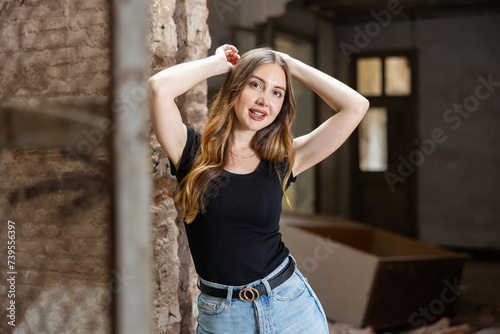 Photo of sensual young european woman inside of deserted building. Portrait of smiling long haired woman in abandoned house.