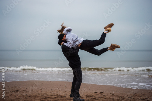 Couple making an acrobatic element at the sea