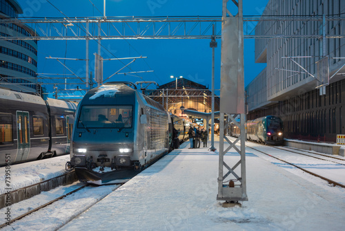 Trains waiting at Bergen train station in early morning ready to depart to the capital. People gathering in front of the train to embark on a journey.