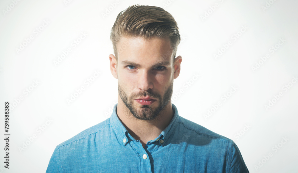 Obraz premium Closeup portrait of sexy fashionable bearded man in denim shirt. Handsome unshaven man with stylish hairstyle. Male fashion. Serious guy with beard and mustache in trendy denim shirt. Casual clothing.