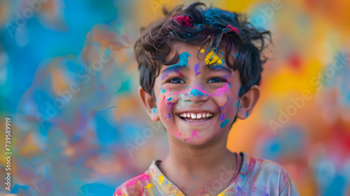 Holi Festival Of Colours. Young Indian boy with a joyful expression covered with colorful Holi powder and smiling brightly. Powder paint in in Goa Kerala