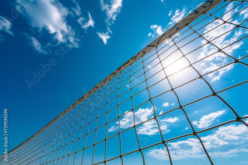 Outdoor beach volleyball with blue sky net and ocean for competition or recreation in summer photo