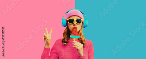 Stylish cool young woman in headphones listening to music on colorful background photo