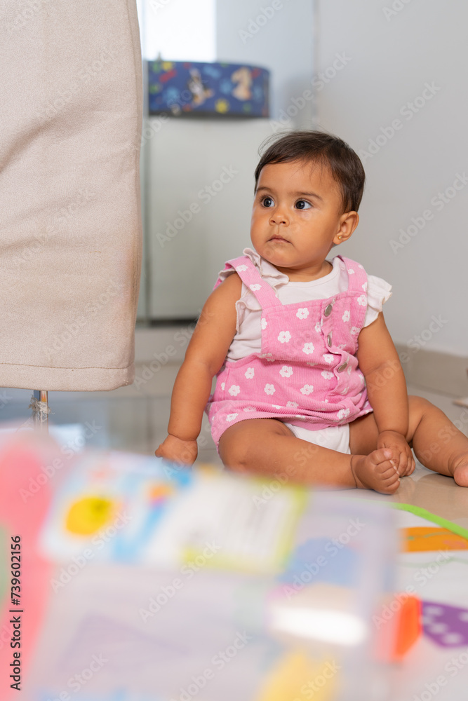 Baby Girl with Curious Expression Playing on Floor Baby Girl with Curious Expression Playing on Floor