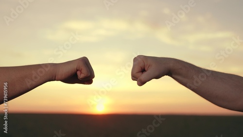 Male fists against sky, trust, harmony, friendship. Business idea. Teamwork concept. Fist to fist sign, expresses consent, gesture of respect. Lifestyle business team clenching their fists closeup.