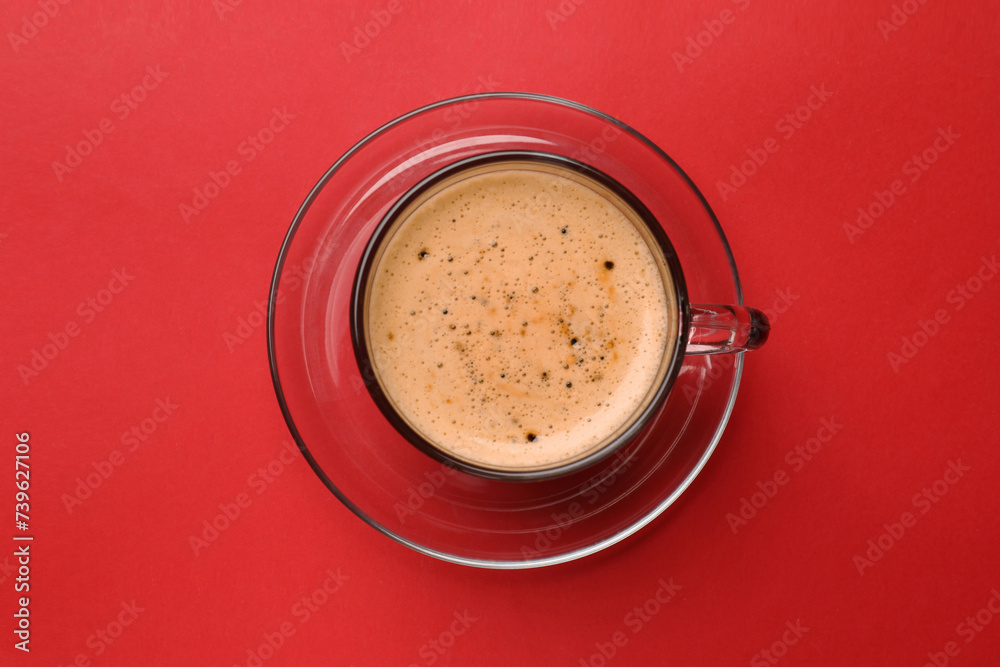 Fresh coffee in cup on red background, top view Fresh coffee in cup on red background, top view