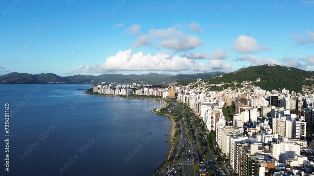 Fototapeta premium Imagem aérea da beira-mar norte da capital Florianópolis com prédios, mar calmo e carros estacionados.