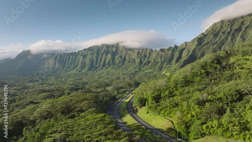 Epic aerial scene H3 highway on Oahu island. Cinematic nature landscape on tropical Hawaii island. Cars driving by scenic route with majestic mountain ridge. Steep green jungle mountains at morning 4K photo