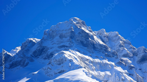 The glistening snow peaks create a stark contrast against the deep blue sky showcasing the beauty of nature.