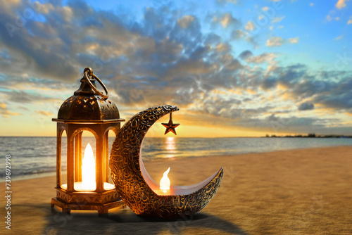 Shiny golden crescent moon with star lantern and arabic lantern on sea beach at beautiful sunset sky with cloud, Ramadan kareem background