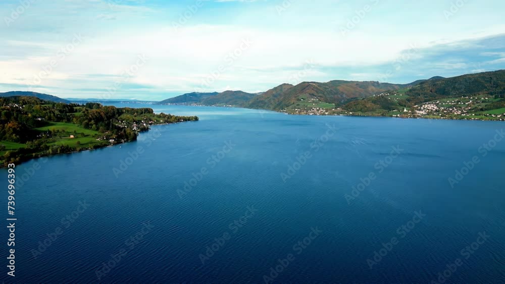 Tranquil mountain lake reflects vibrant autumn foliage. Sunlight filters through golden leaves, casting dappled light on calm water Tranquil mountain lake reflects vibrant autumn foliage. Sunlight filters through golden leaves, casting dappled light on calm water