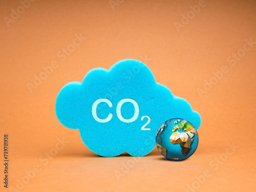 Reduce CO2 emissions, limit climate change, global warming, net zero carbon dioxide footprint reduction, decarbonize concepts. text, CO2 on blue cloud sponge with 3d globe on kraft paper background.