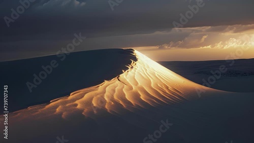 The stark contrast of a darkened sky and glowing dunes at sunset. photo