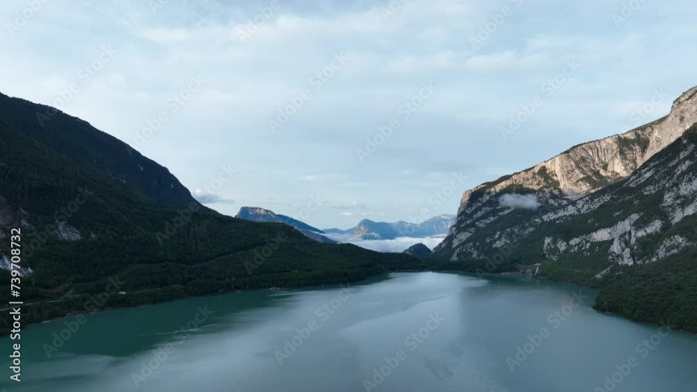 Drone flying over Molveno lake surrounded Dolomites mountains, Trentino in Italy. Aerial forward ascending and space for copy Drone flying over Molveno lake surrounded Dolomites mountains, Trentino in Italy. Aerial forward ascending and space for copy