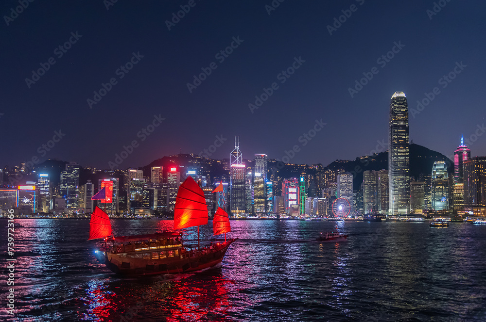 Tourist ship in Victoria Harbor of Hong Kong city at night