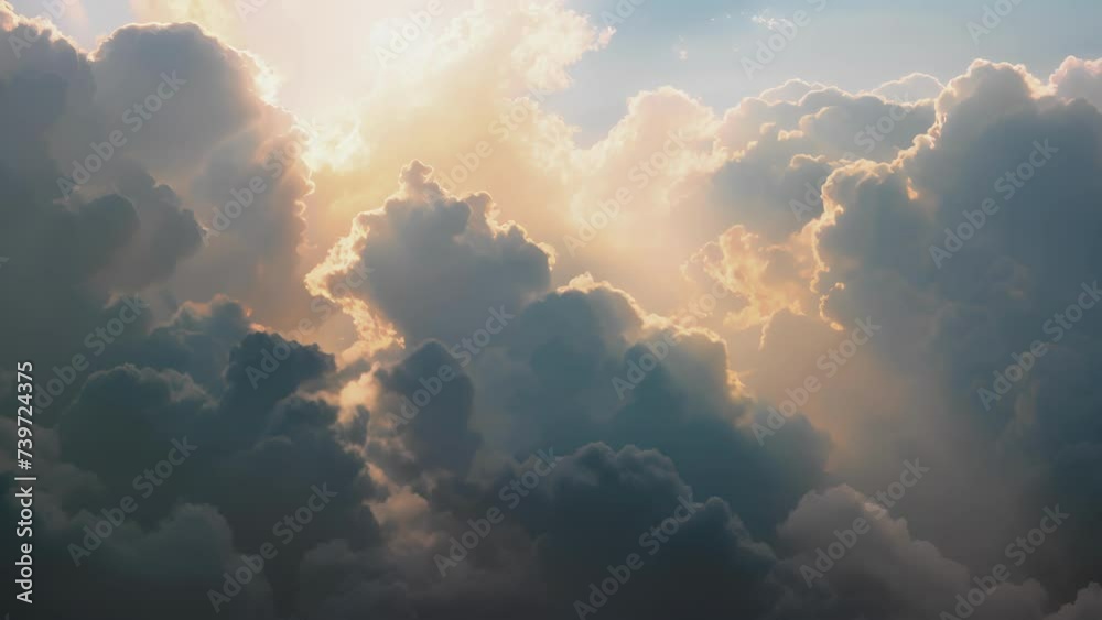 Billowing clouds backlit by the rising sun casting shadows over the landscape below.