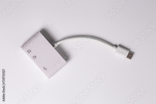 White charger with dual USB ports and SD card reader on white surface