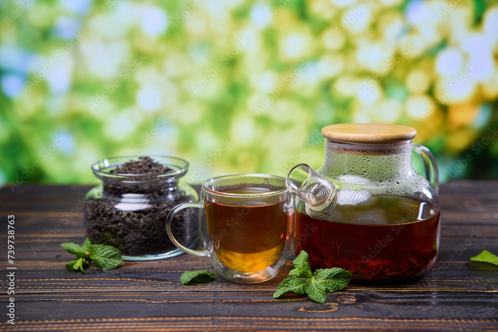 natural organic herbal tea in glass teapot and cup on a wooden table natural organic herbal tea in glass teapot and cup on a wooden table