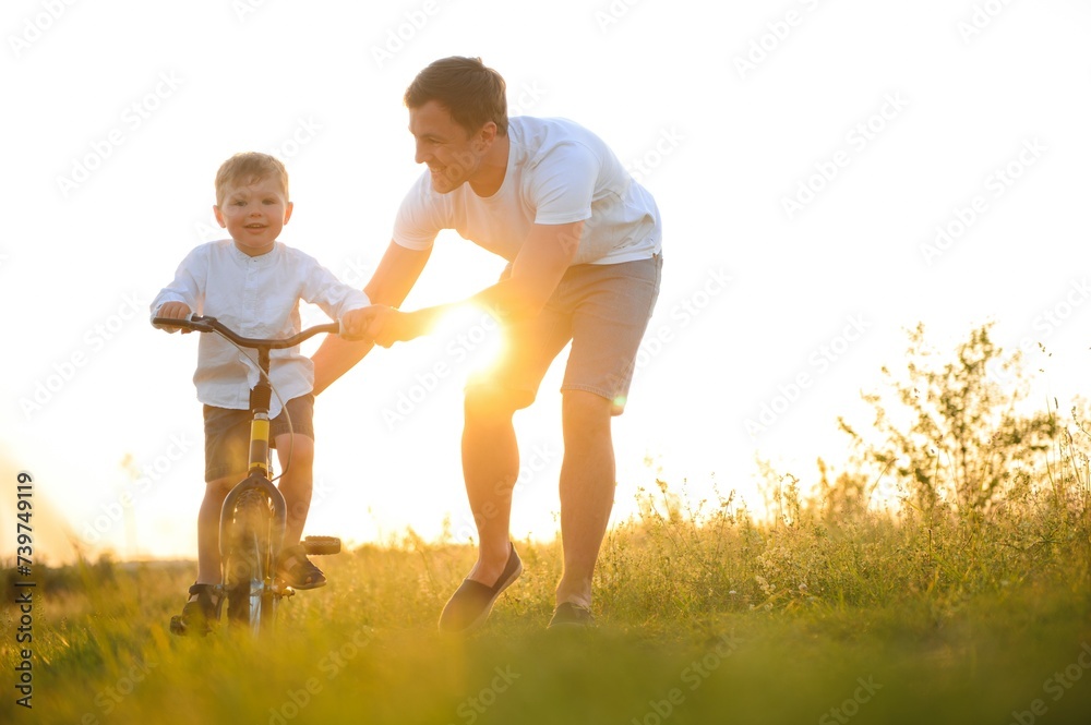 Father teaching his son how to ride a bicycle Father teaching his son how to ride a bicycle