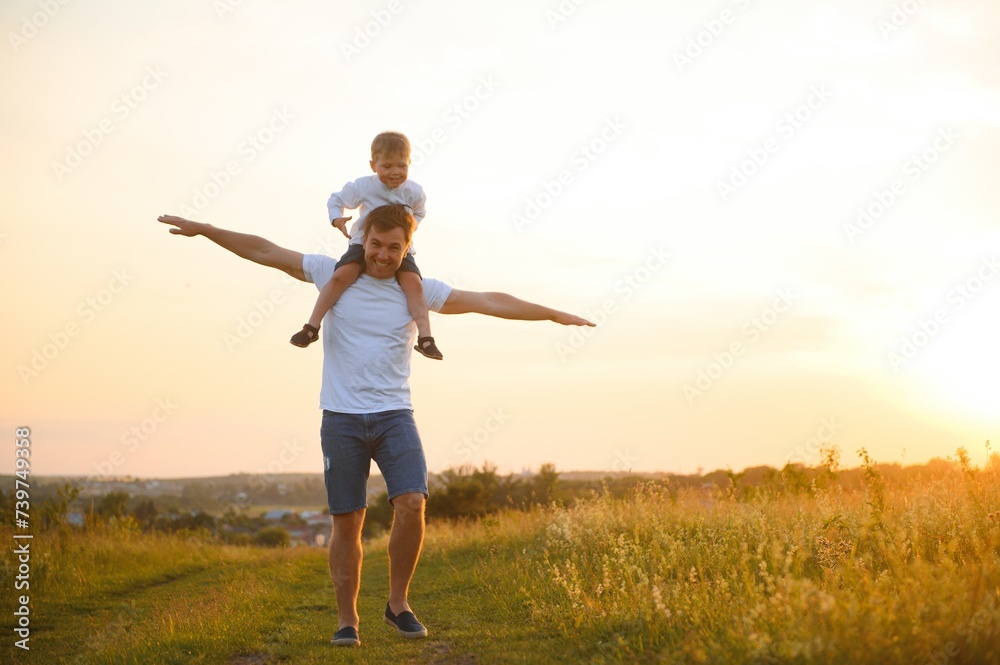 Happy father playing with son on sunset background .The concept of father's day