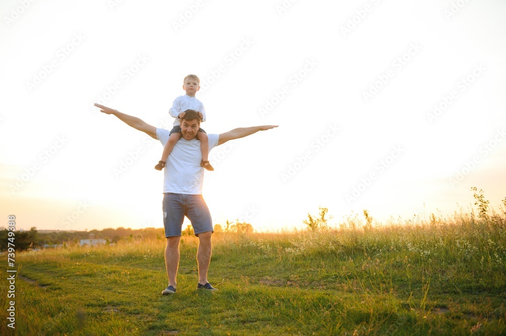 father's day. Dad and son playing together outdoors on a summer. Happy family, father, son at sunset. father's day. Dad and son playing together outdoors on a summer. Happy family, father, son at sunset.