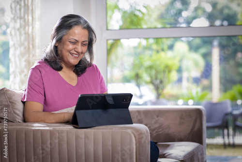 Beautiful senior woman working on digital tablet at home Free Download Beautiful senior woman working on digital tablet at home - GFXLoad