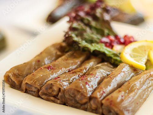 MALFOOF or Stuffed Cabbage leaves rolls with lime and salad served in dish isolated on wooden table top view of cold mazza arabic food photo