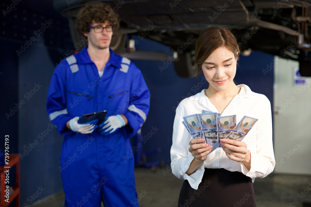 businesswoman or customer holding and counting cashes pay for technician in automobile repair shop