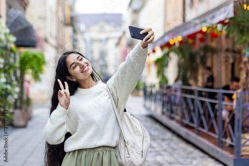 Photography Smiling young Indian woman traveling and walking on city street, standing and ta