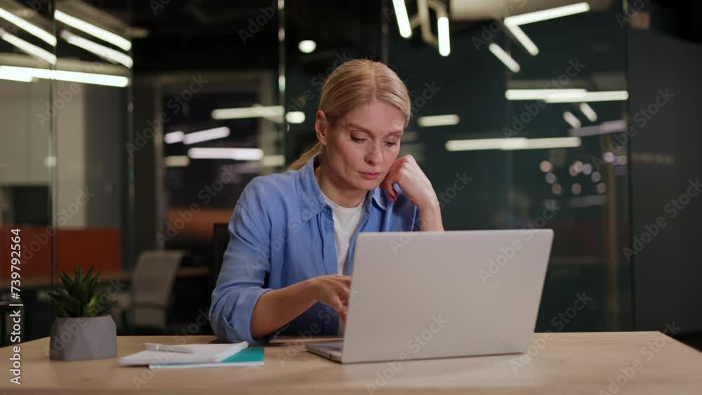 Young woman in casual outfit sitting at desktop and typing on laptop while getting annoyed with difficult task. Nervous female feeling bored while working on computer and sending emails to customers. Young woman in casual outfit sitting at desktop and typing on laptop while getting annoyed with difficult task. Nervous female feeling bored while working on computer and sending emails to customers.