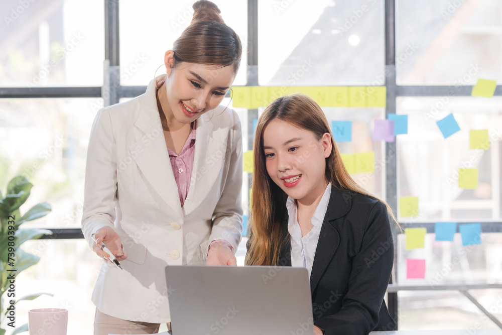 Two young Asian business woman talk, consult, discuss working with new startup project idea presentation analyze plan marketing and investment in the office. Two young Asian business woman talk, consult, discuss working with new startup project idea presentation analyze plan marketing and investment in the office.