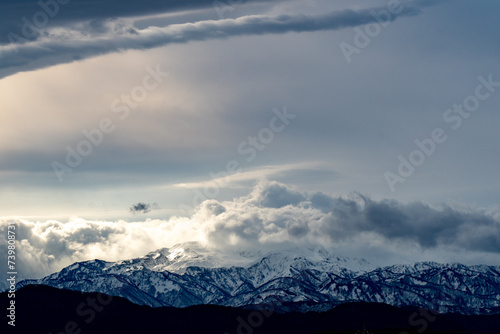 光に照らされる雲と雪山