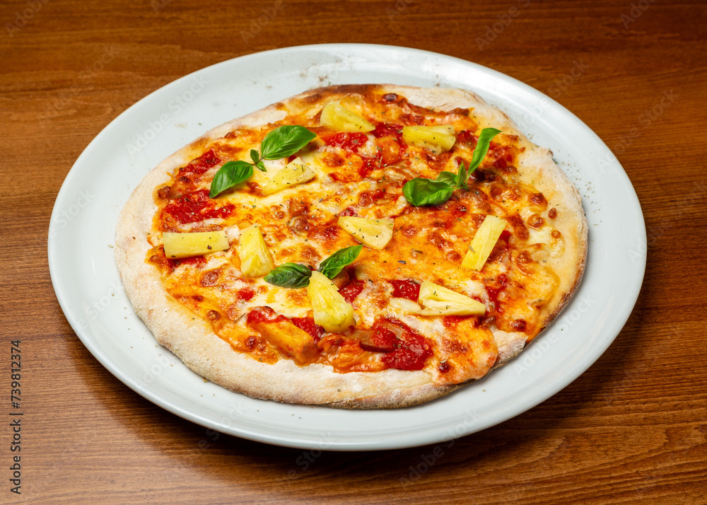 Hawaiian pizza with cheese and pineapples on a plate. Hawaiian pizza with cheese and pineapples on a plate.
