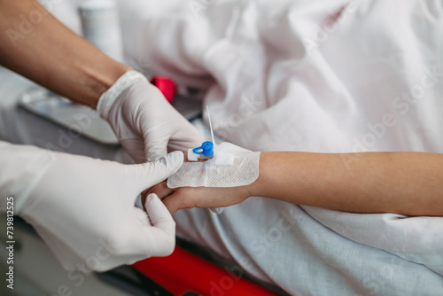 Close up of nurse insering IV cannula in little girl hand. IV, intravenous therapy for child patient. photo