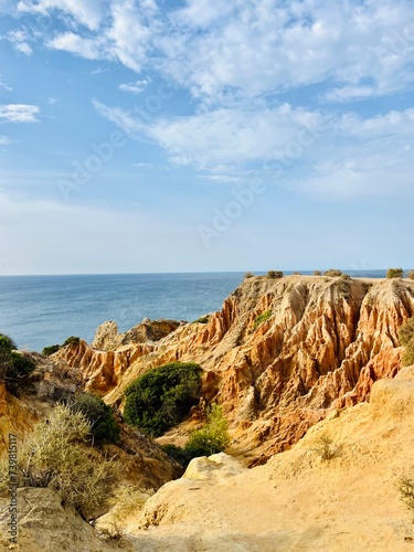 Sandstone rocky ocean coast, natural orange color of the hill