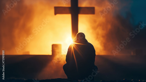 Christian man praying in front of the cross photo
