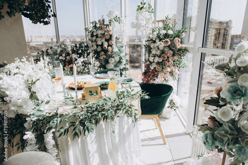 Wedding celebration hall with wedding arch decorated with flowers and white fabric