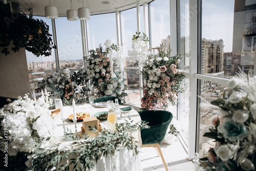 Wedding celebration hall with wedding arch decorated with flowers and white fabric