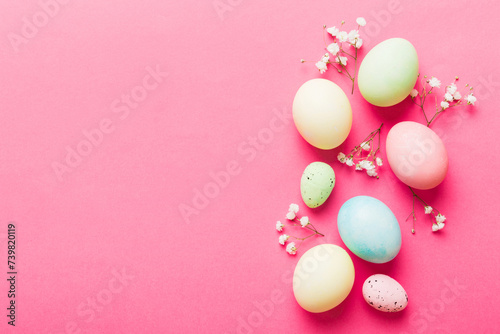 Happy Easter composition. Easter eggs on colored table with gypsophila. Natural dyed colorful eggs background top view with copy space