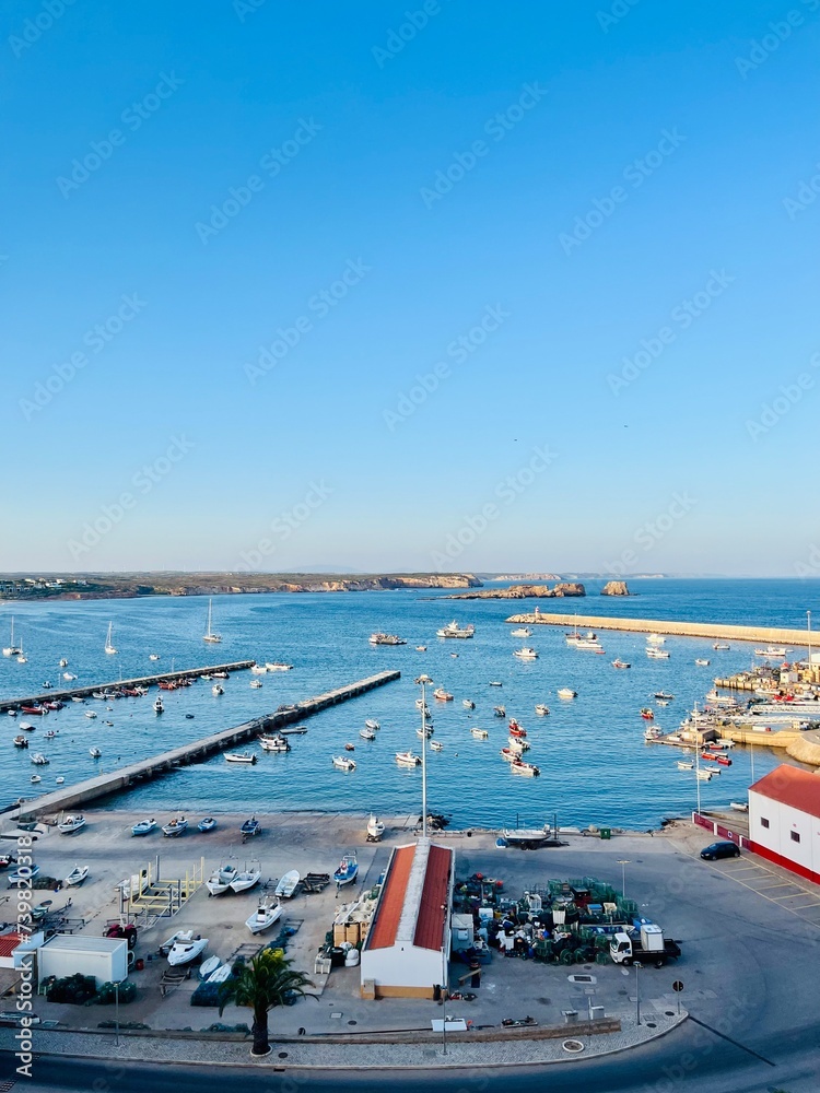 View to the small dock with yachts and boats, ocean coast, blue sky