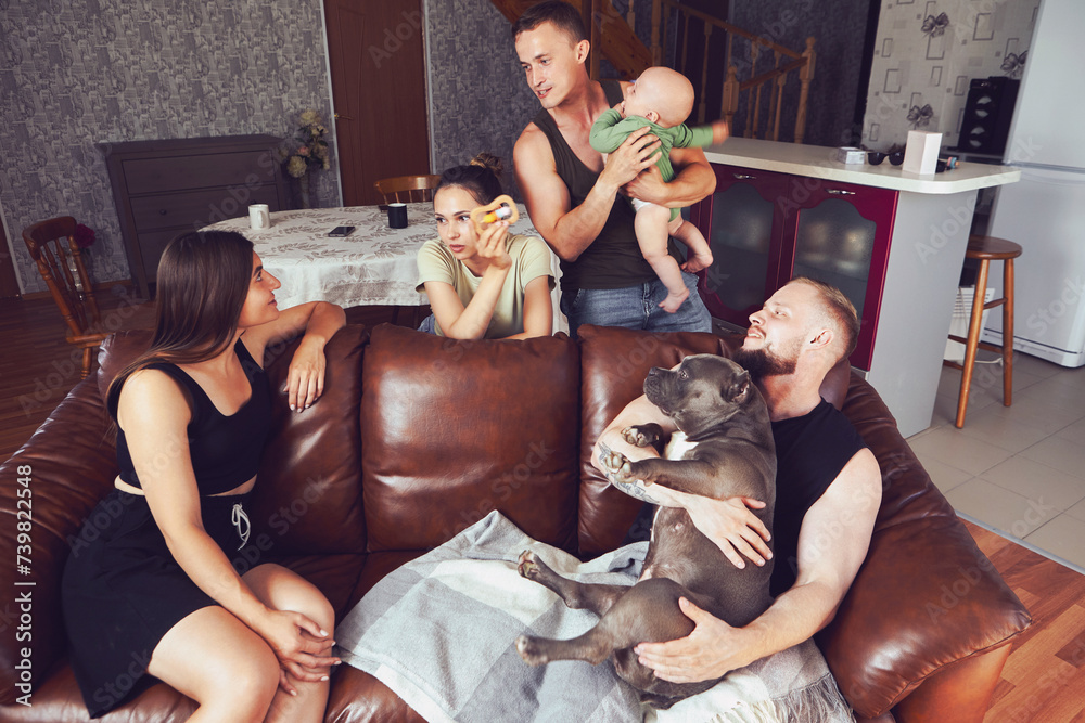 Two young European couples came to relax in country house, some have an American Bully dog, other baby girl.