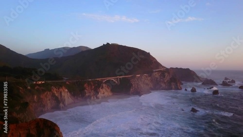 Bixby Creek Bridge Big Sur California aerial cinematic drone flight Pacific Ocean Nor Cal winter summer big wave swell crashing shoreline late afternoon golden hour sunset upward slowly movement