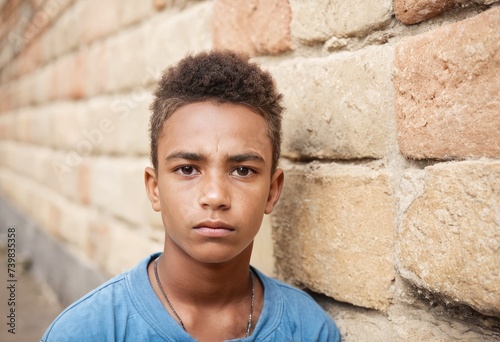 Lonely sad african american teenager boy against an urban old wall. Young homeless boy.