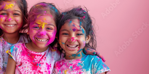 Banner with smiling indian girls with Holi color powder on face. Banner with pink copyspace. Holi color festival concept. Shallow depth of field.