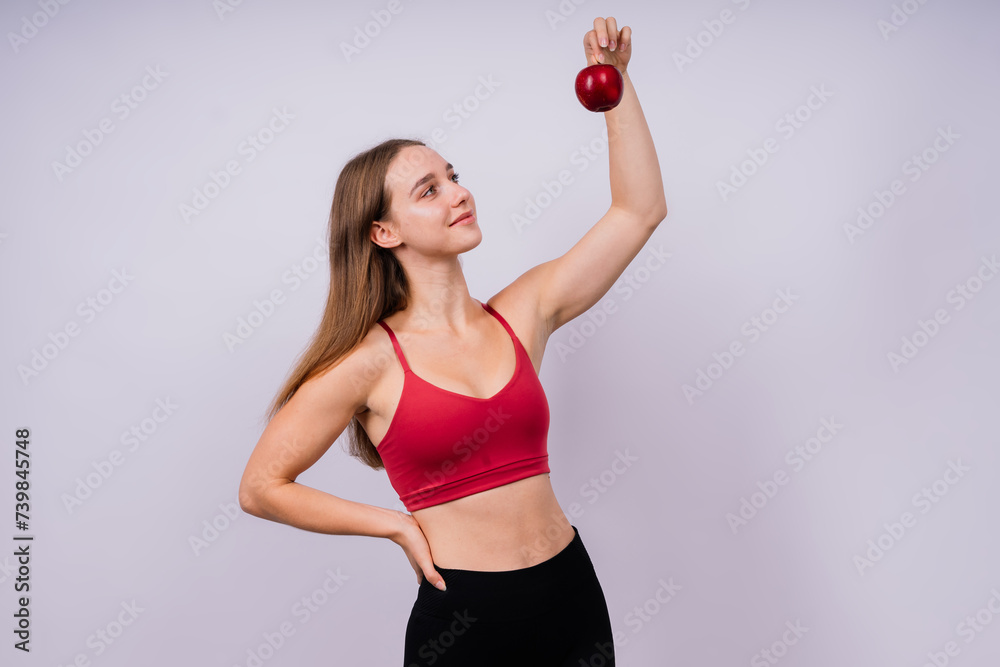 Cropped of sporty female with well fit body holding apple, healthy food and fit body concept Cropped of sporty female with well fit body holding apple, healthy food and fit body concept