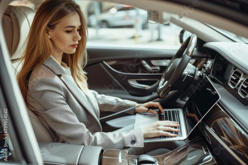 beautiful businesswoman working on laptop computer while sitting in luxury car © Kien