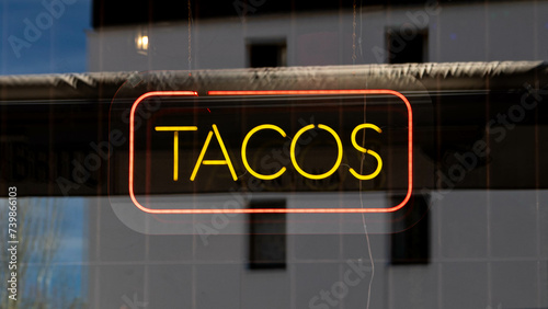 Neon Street sign that says Tacos, mexican restaurant
