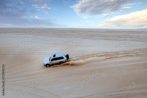 A Toyota Land Cruiser climbing up the desert mountain in Sealine Sand Dunes, Mesaieed, Qatar. photo