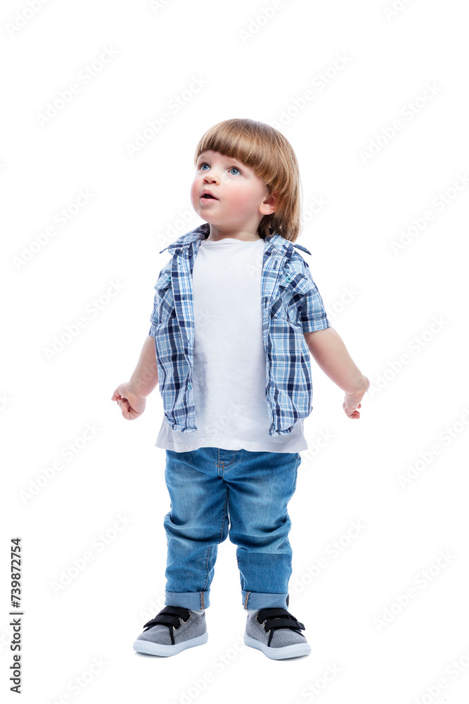 A surprised little boy looks up. A child with a fashionable haircut in jeans and a blue plaid shirt. Full height. Isolated on a white background. Vertical. A surprised little boy looks up. A child with a fashionable haircut in jeans and a blue plaid shirt. Full height. Isolated on a white background. Vertical.